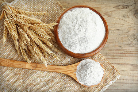 在碗里用木制的桌子，顶视图上的小麦耳朵整个面粉