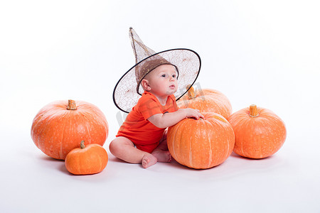 Baby in orange t-shirt on a white background sitting in a witche