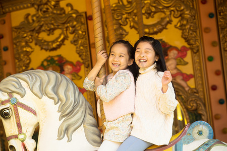 两个小女孩在玩旋转木马