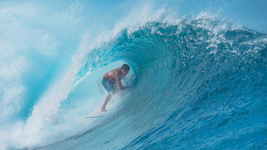 冲浪浪花摄影照片_特写: 亲冲浪者拖着手沿着巨大的绿松石浪花卷曲在头上。令人叹为观止的是, 一个冲浪者在法属波利尼西亚冲浪, 他身后的电波疯狂地飞溅.