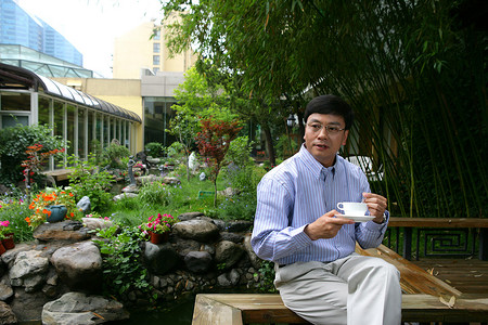 喝咖啡表情摄影照片_商务人士在酒店阳台饮茶喝咖啡