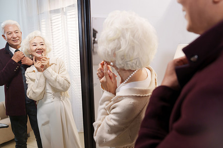 狭叶珍珠菜摄影照片_时尚的老年夫妇对着镜子穿衣打扮