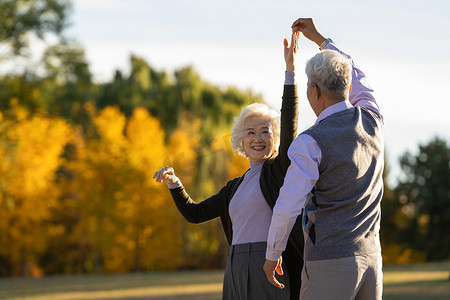 舞蹈黄色摄影照片_幸福的老年夫妇在户外跳舞