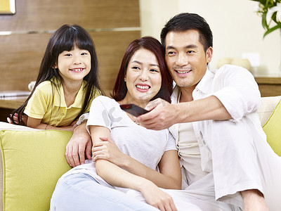 亚洲父母和女儿在家里看电视