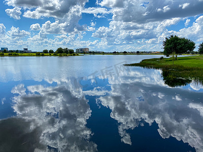 在一个美丽的夏日，天空中的云朵映衬着平静宁静的湖面.