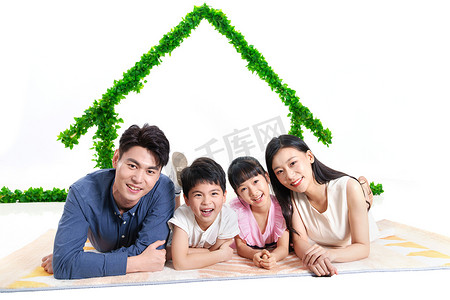 健康绿色环境摄影照片_绿色房子下趴着的幸福家庭
