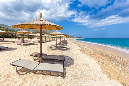 rows摄影照片_Beach umbrellas in rows on sandy beach with sea