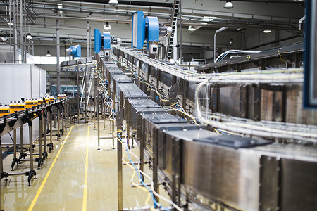 工业工厂室内和机械。用于加工和装瓶汽水和橙汁瓶的机器人生产线。选择性对焦。野外深度短.