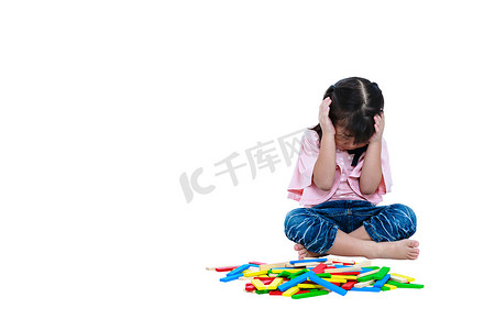亚洲的孩子在玩玩具木块。伤心的女孩哭，表现出情绪化的行为。白色背景上孤立.