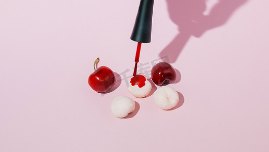 painting摄影照片_Painting cherries on a pink background. Minimal concept with a shadow.