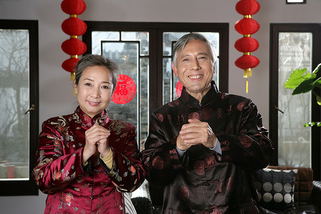 拜年剪纸摄影照片_中国老年夫妇拜年