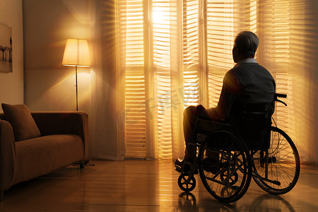 窗前摄影照片_窗前孤独的老年人坐在轮椅上