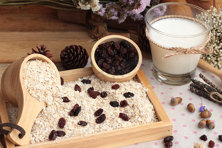 dried摄影照片_Oat flakes with currant dried fruit and milk