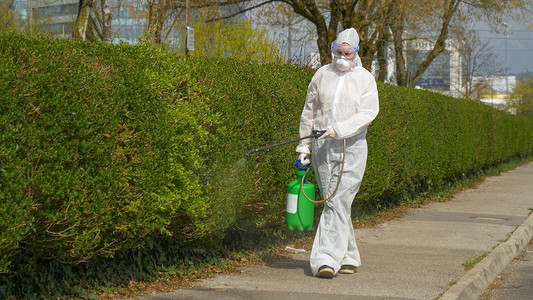 Civil protection worker sprays the empty suburbs with antiviral sanitizer.