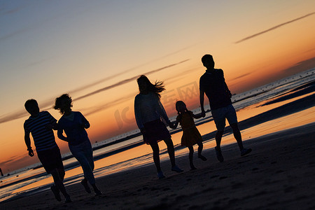 奔跑的人剪影摄影照片_在海边度假的快乐家庭