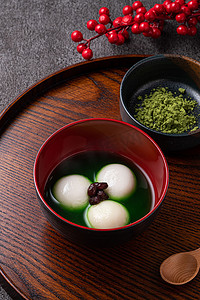 tangyuan摄影照片_Close up of matcha big tangyuan (tang yuan) with sweet matcha soup in a bowl on gray table background for festival food.