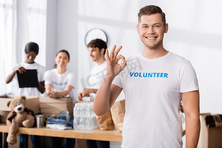 在慈善中心的相机前，志愿者有选择地对着镜头做一个好的手势 