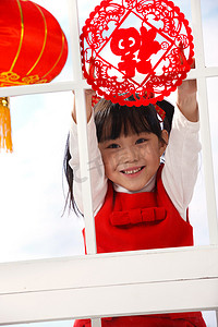 春节背景窗户摄影照片_小女孩贴窗花