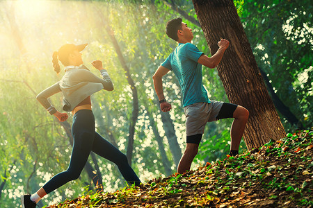 周末活动摄影照片_青年情侣在树林里跑步
