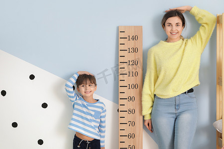 小男孩和他的母亲在家里测量身高