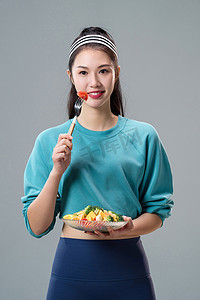 轻食沙拉图片摄影照片_吃蔬菜沙拉的青年女人
