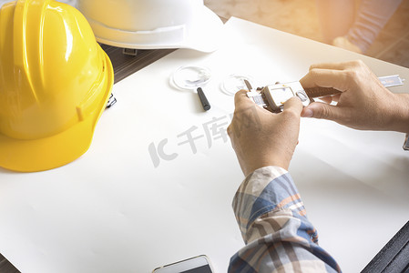 建筑工程师测量游标卡尺。业务和技术理念。安全帽和图纸元素。