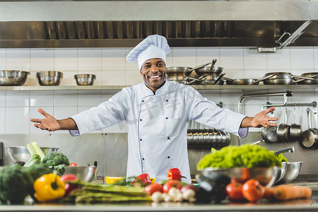 美国餐厅摄影照片_英俊的非洲裔美国厨师站在餐厅厨房张开双臂