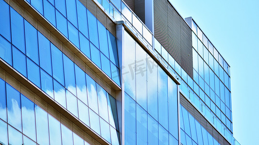 现代建筑覆盖在反射式玻璃板玻璃上的玻璃外墙的抽象特写。建筑的抽象背景。玻璃墙和立面细节.