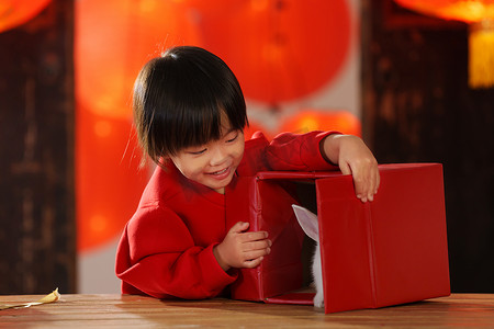 礼物元素摄影照片_可爱的小男孩打开新年礼物