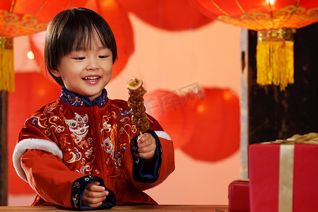 新年发发发摄影照片_可爱的小男孩拿着糖葫芦庆新年