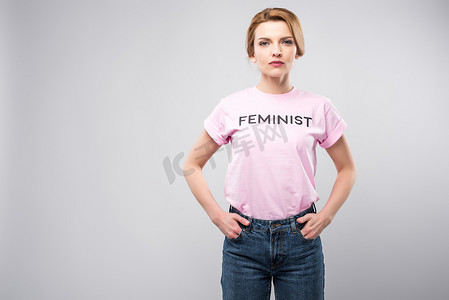 妇女在粉红色女权主义 t恤衫摆在口袋里, 孤立的灰色