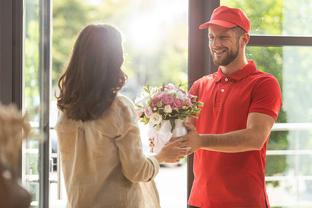 选择性的焦点快乐男人在帽子给女人送花 