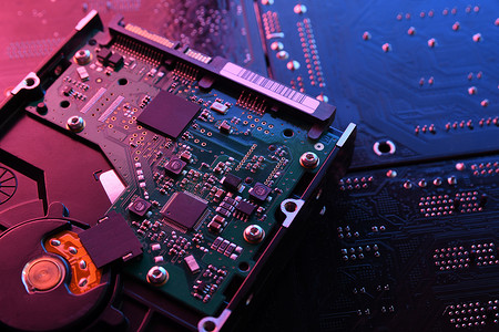 计算机硬盘驱动器HDD, SSD在电路板上,主板背景.特写。红蓝相间