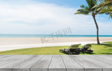 有夏季海滩的木制桌子空旷的顶部,有天空背景的海滩椅子.产品展示、广告及推广用途.