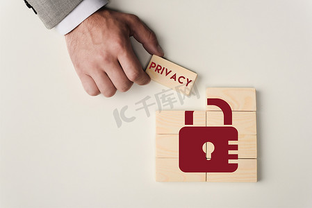 部分视图的人拿着砖与 ' 隐私 ' 文字在木块与锁图标查出在白色