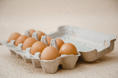 10个褐色的鸡蛋放在桌上的纸盘里