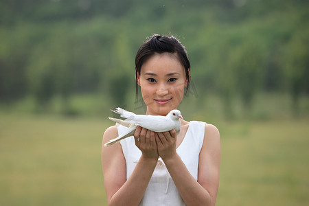 东方女人户外手捧和平鸽