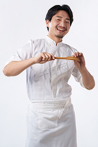 厨师胡子摄影照片_穿着厨师服的中年男人拿着铲子