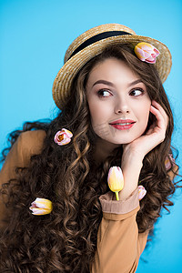 周到的年轻女子在 canotier 帽子与郁金香在她的长卷发