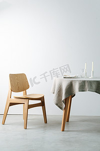一张白色桌布和一把厚实木椅的圆桌侧视图