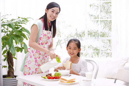 餐桌吃早饭摄影照片_东方母女两人吃早饭