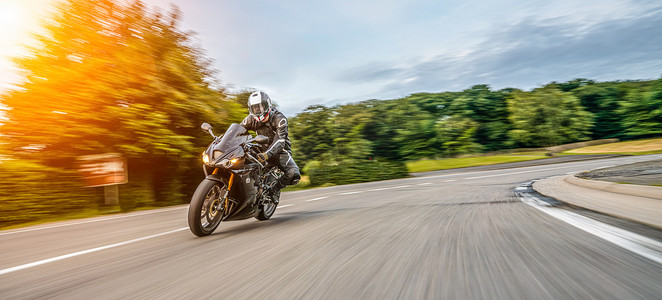 摩托车在路上开得很快。在空旷的高速公路上骑摩托车玩的开心。个别文本的版权空间.