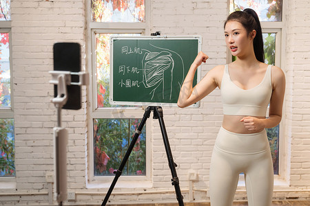 肌肉真人摄影照片_年轻女人在线直播健身授课
