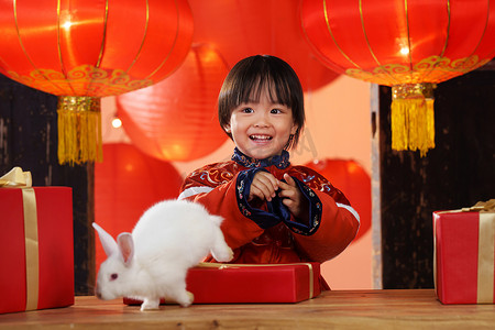 兔子新年春节摄影照片_可爱的小男孩收到新年礼物小兔子