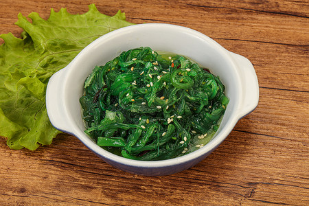 绿色朱卡海藻色拉分离在白色背景顶部视图。Wakame Sea Kelp Salat, Chukka Sea Weed, Healthy Algae Food