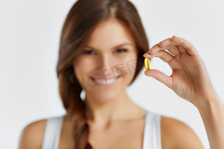 oil摄影照片_Nutrition. Healthy Lifestyle. Woman Holding Pill With Fish Oil O