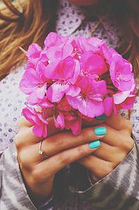 蓝绿色摄影照片_时尚女士与茶她手里拿着束粉红色的花