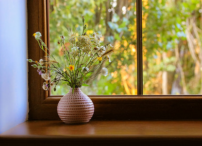summer水纹摄影照片_Bouquet of different wildflowers in a pink vase on a wooden window sill against a window at summer sunny day. Flowers in the home interior. Cosy homy atmosphere. Place for text. Natural background.