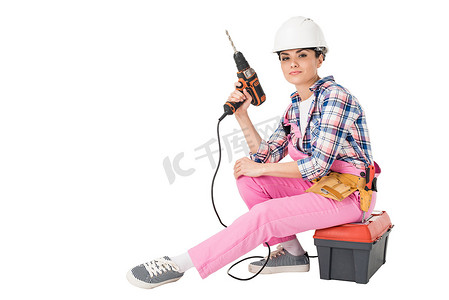 专业建设者在工作服和安全帽举行演习, 而坐在工具箱上的白色隔离