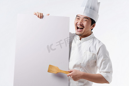 狂欢激动摄影照片_穿着厨师服的中年男人拿着白板